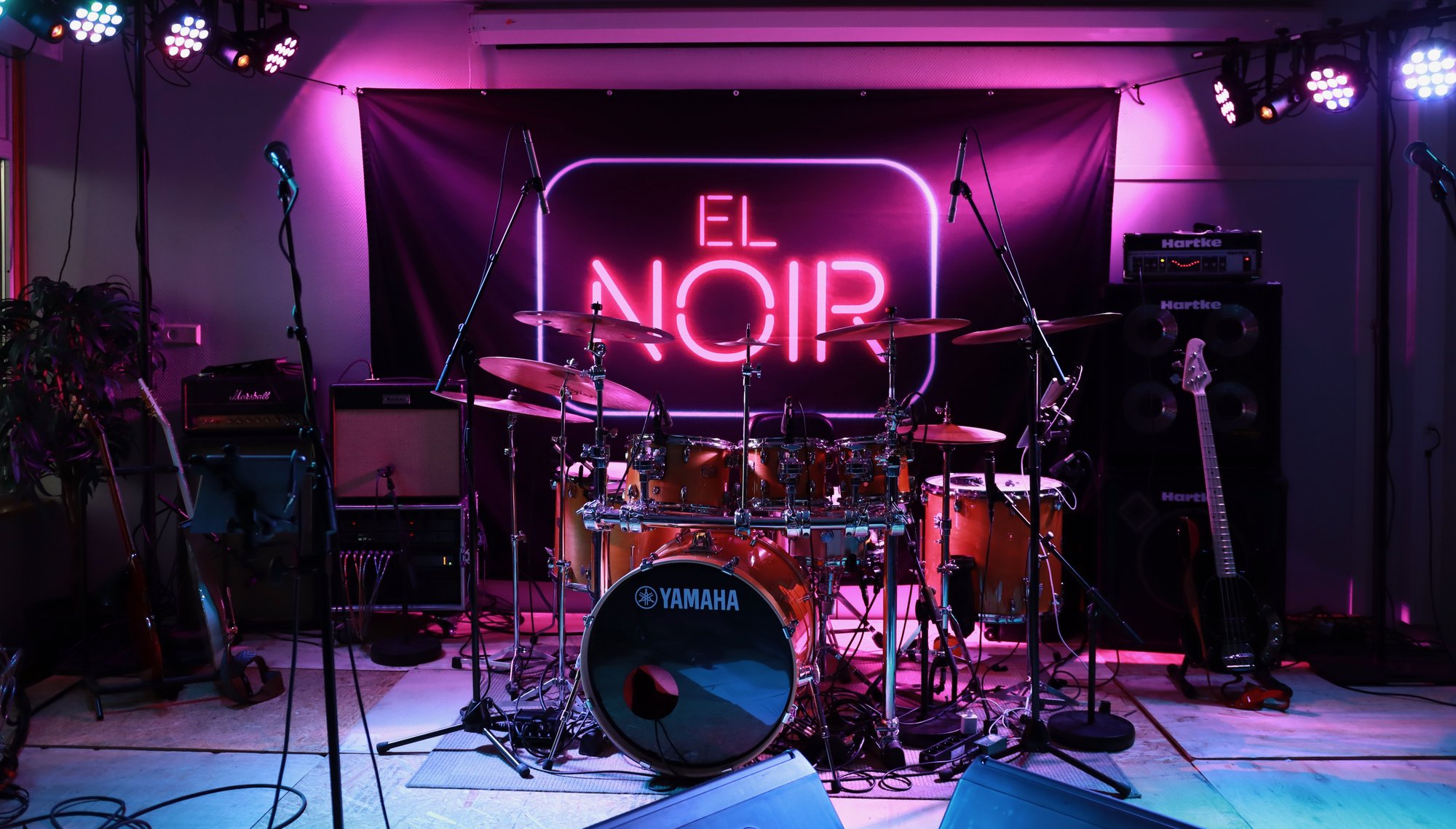 El Noir-scenen med trommesett og neon-skilt
